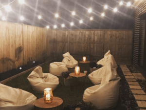 gold bean bags with timber top coffee tables and gold lamps in backyard