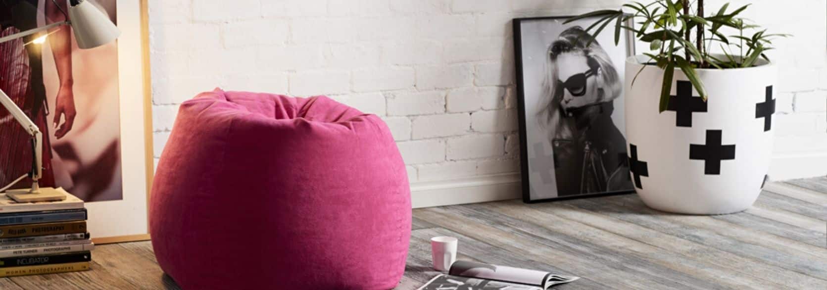 pink bean bag on floor next to coffee cup and magazine